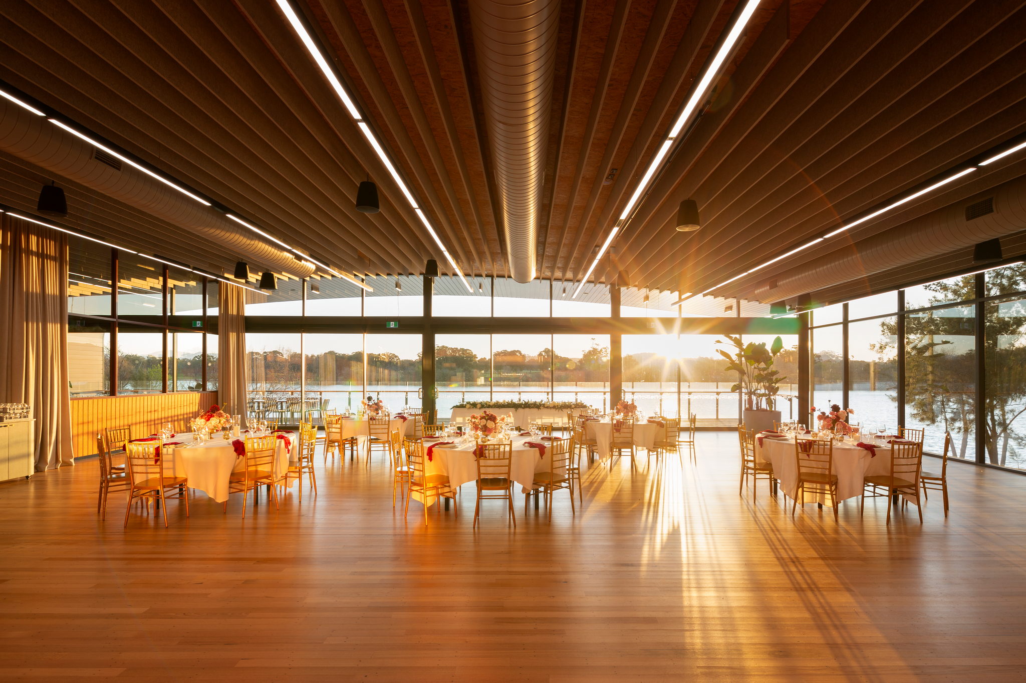 The Telopea Room set for a wedding, lake and sunset beyond