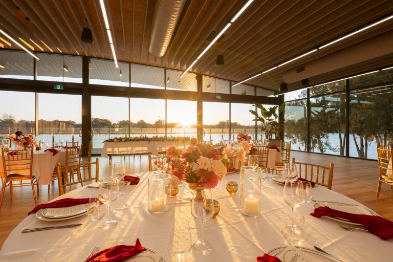 Wedding tablescape at sunset with the lake glowing through the glass