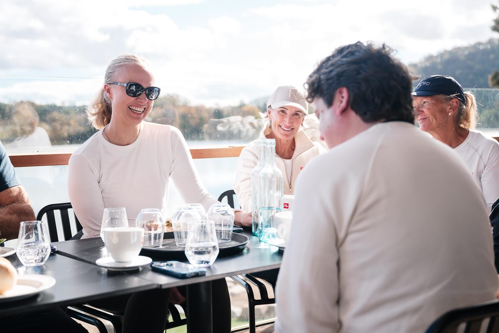 Cross-generational laughter around a table in lake light