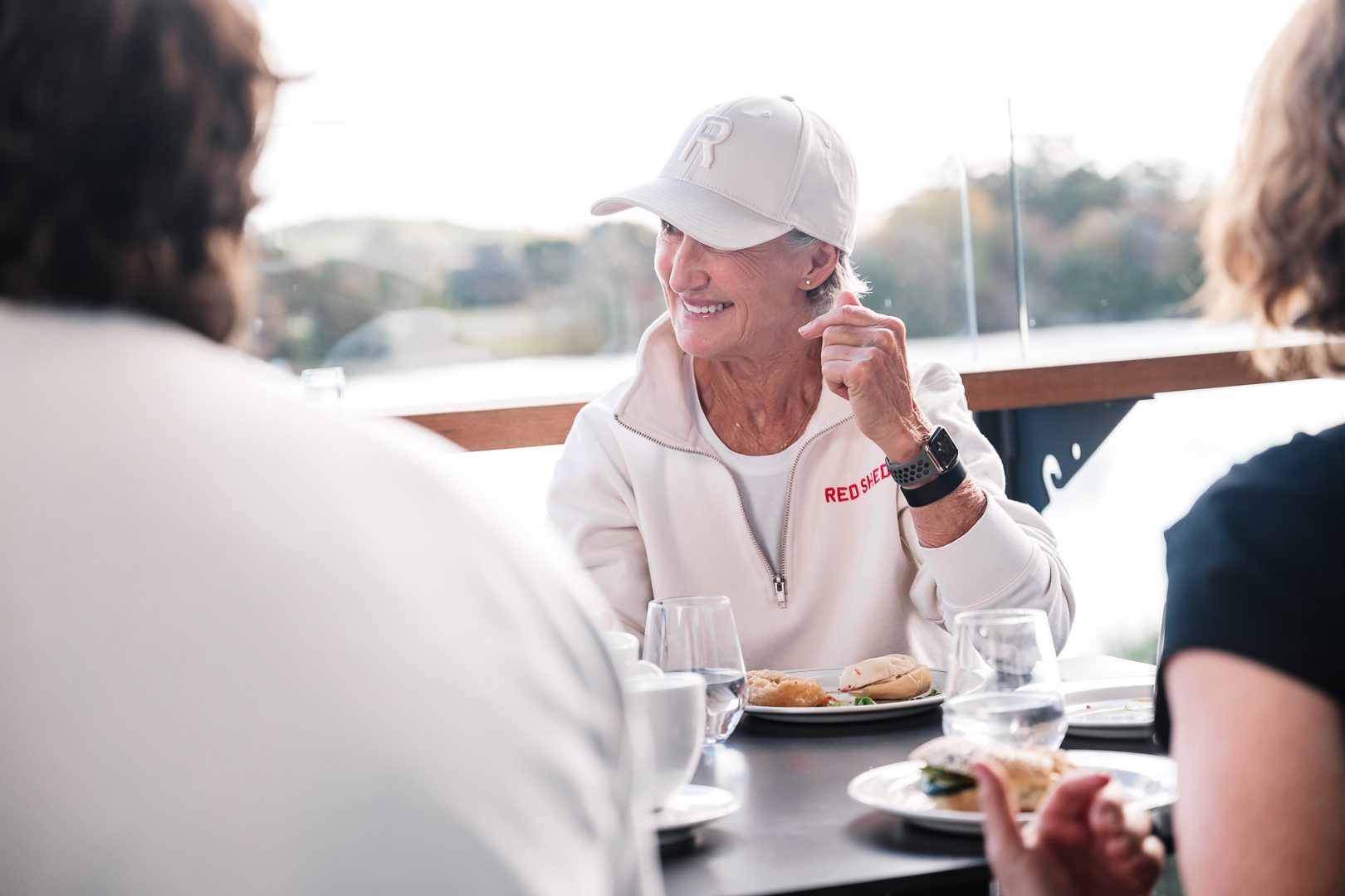 Members smiling over food at the Easy Oar cafe in golden light