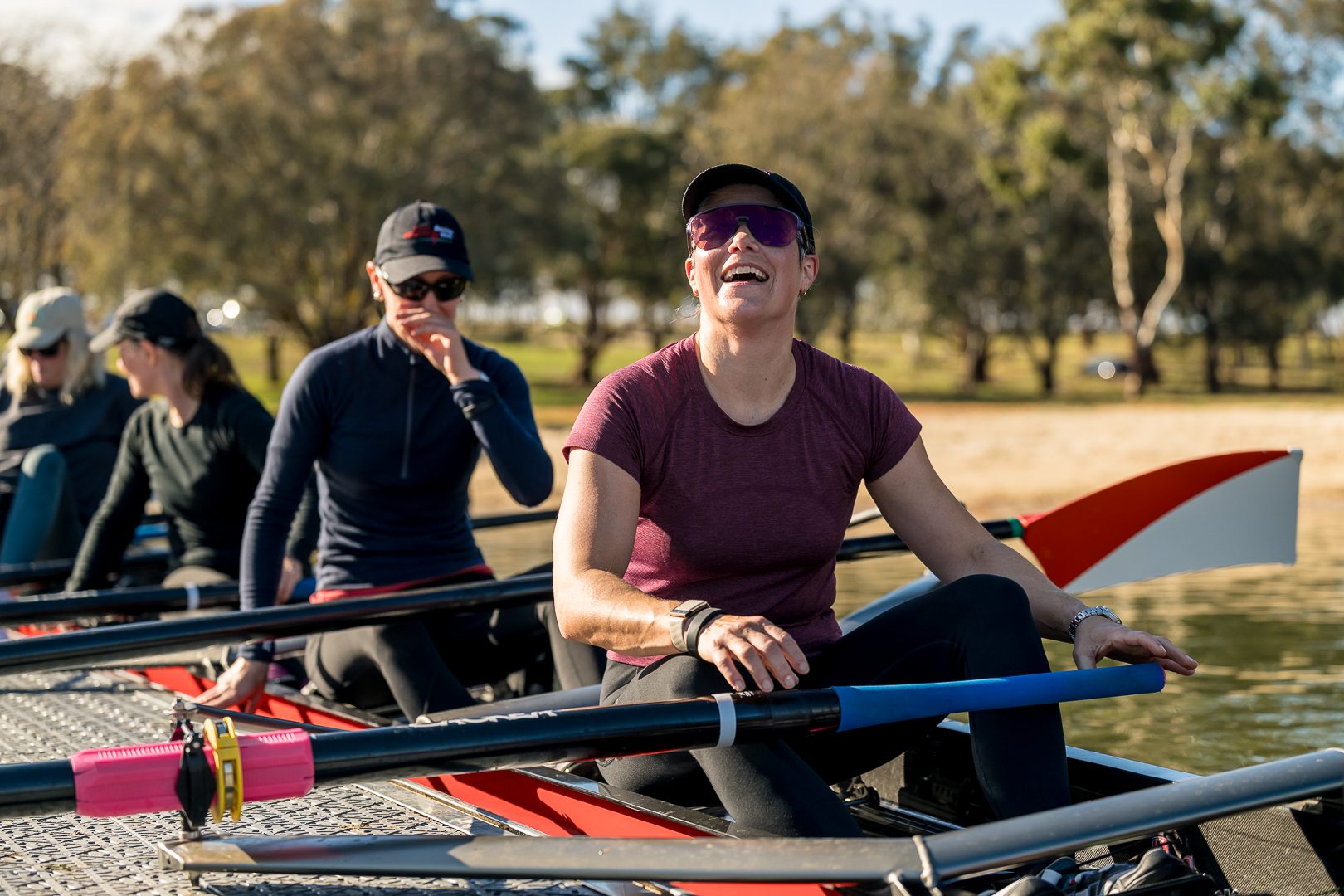 Rower laughing with her crew at the dock after a session