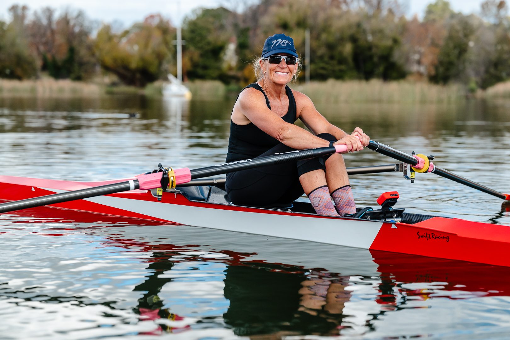 Member grinning at rest in a red single scull