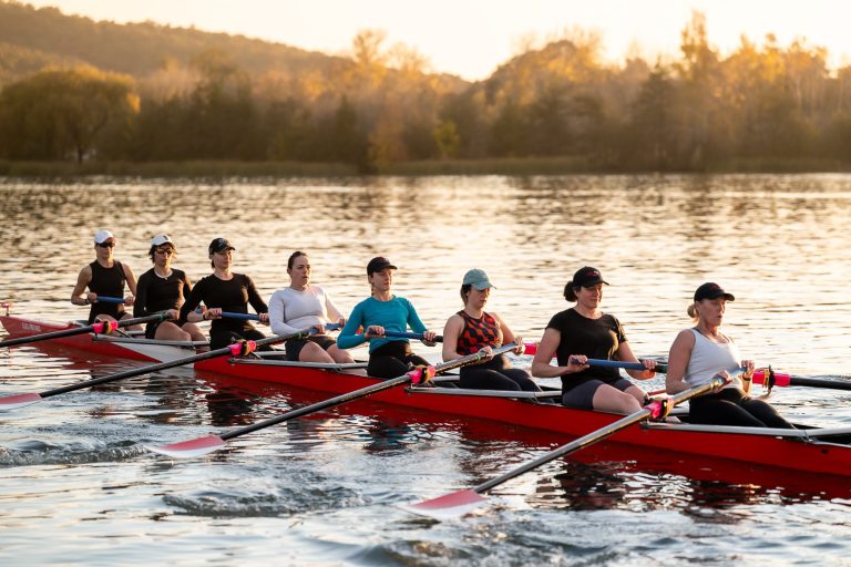 Women's eight rowing on Lake Burley Griffin at golden hour
