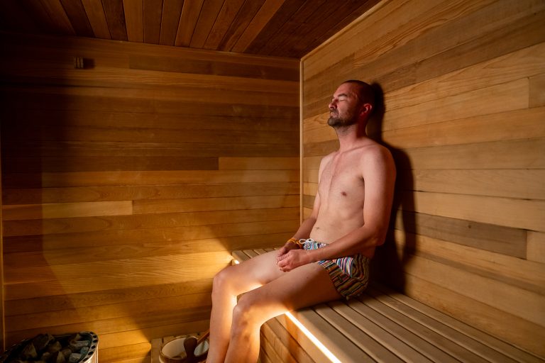 Member resting back in the warm cedar sauna