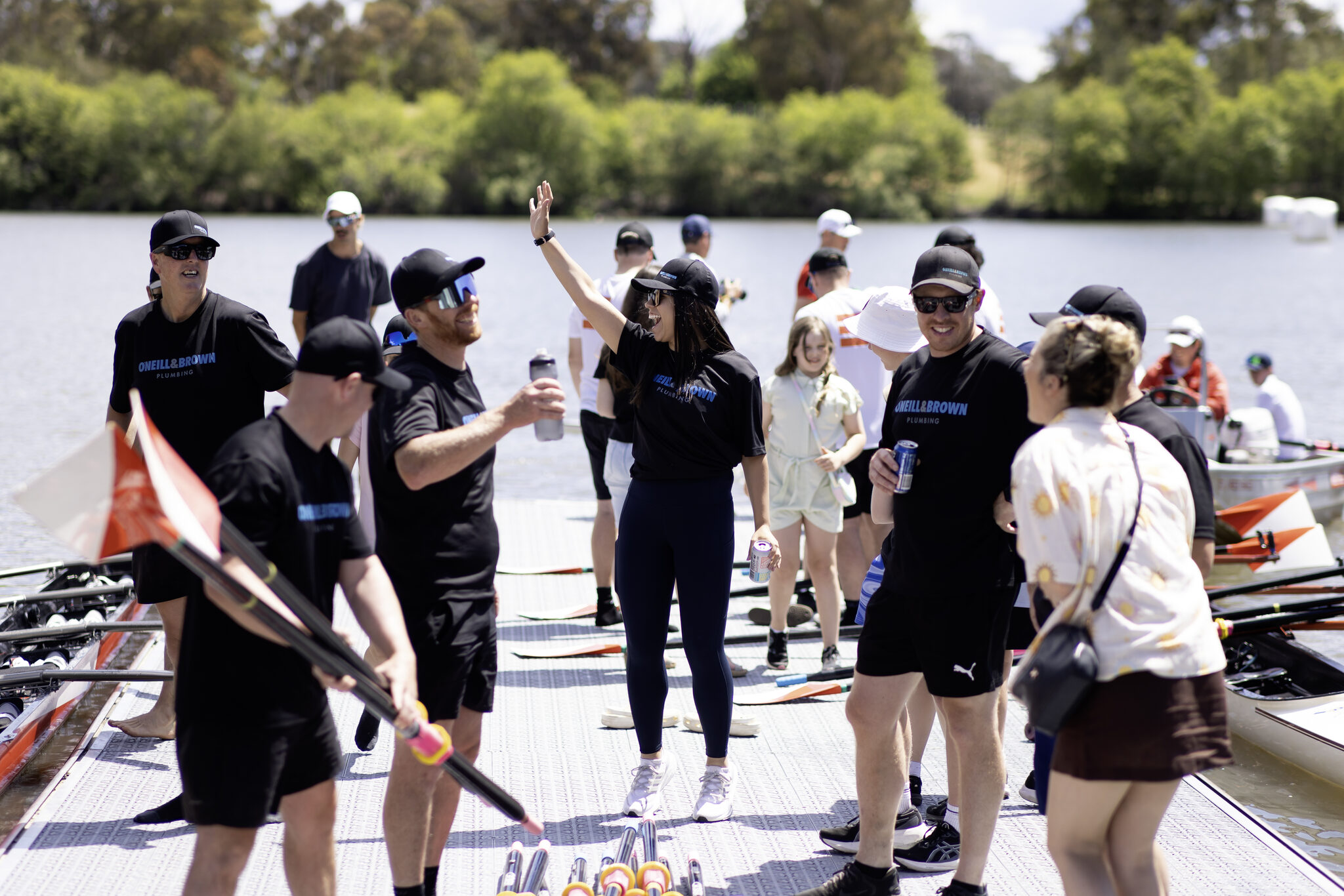 A workplace group on the Red Shed pontoon with their boats before a session