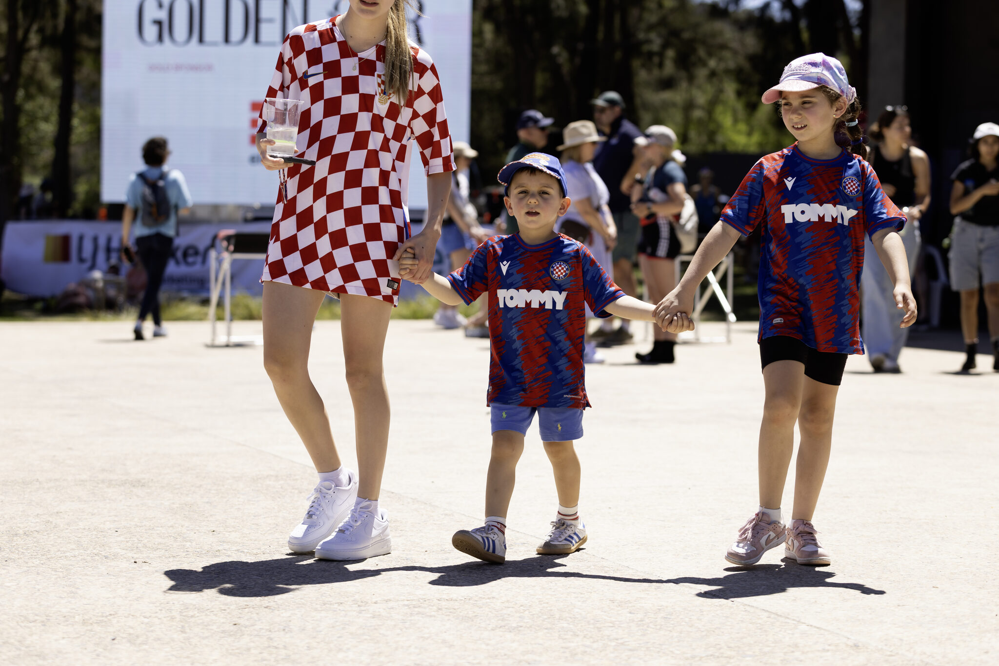 A family walking past the Golden Oar banners on regatta day
