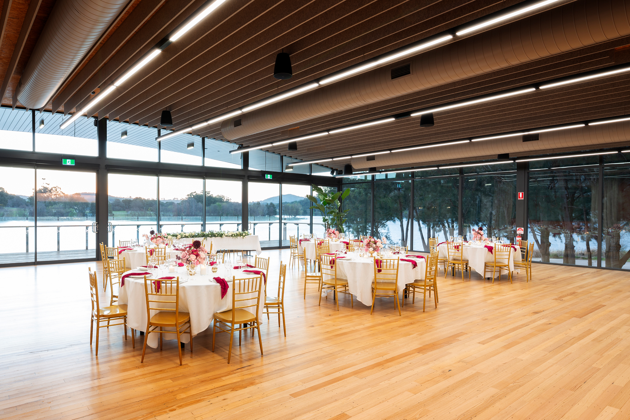 The Telopea Room at twilight with candlelit tables and the lake beyond