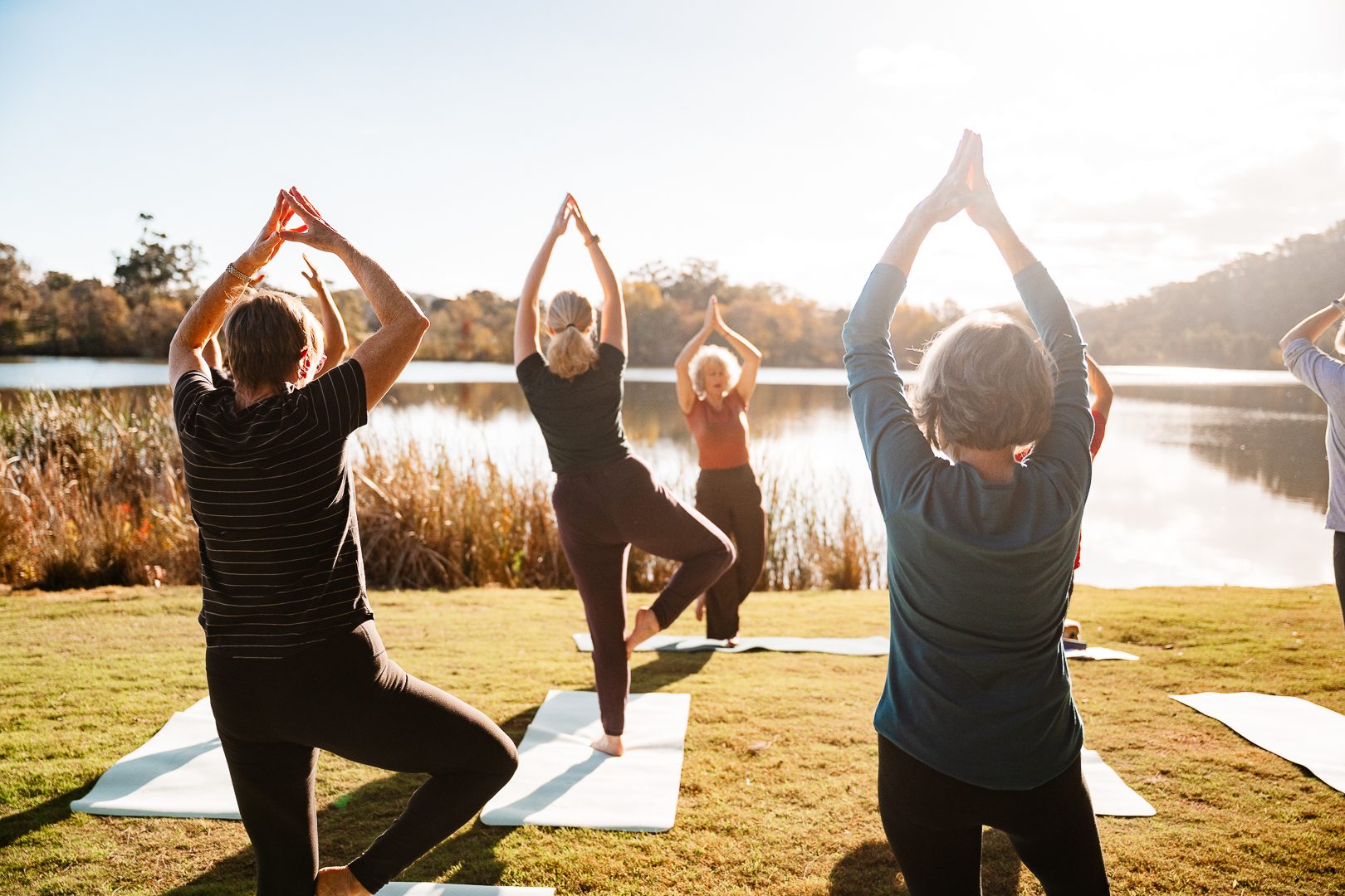Golden hour yoga on mats facing the still lake